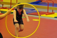 Katie does a forward roll through the hoop...