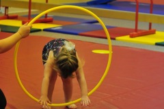 Katie does a forward roll through the hoop...