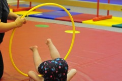 Katie does a forward roll through the hoop...
