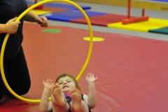 Katie does a forward roll through the hoop...