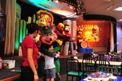 Nicholas gets a hug from Chuck E. Cheese...